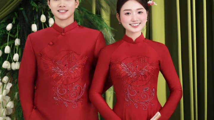 Cặp đôi mặc áo dài đỏ truyền thống tạo dáng trong studio với phông nền xanh sang trọng.