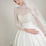Cô dâu mặc váy cưới ren trắng sang trọng được chụp trong studio.