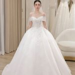 Một cô dâu mặc váy cưới trắng lộng lẫy trong studio.