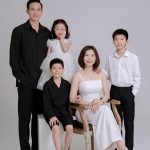 Ảnh chụp gia đình với phong cách hiện đại, thanh lịch trên nền studio trắng.