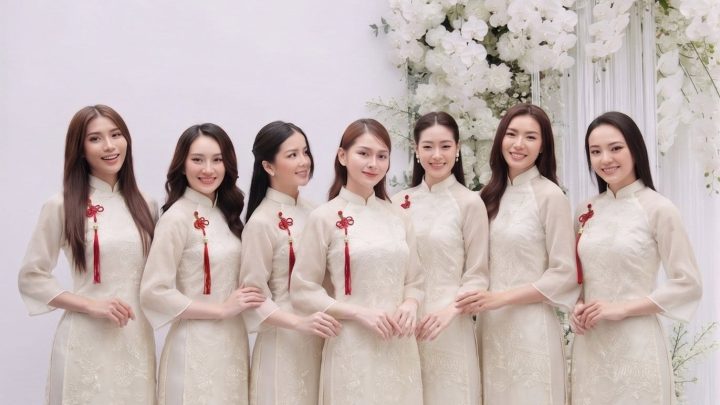 Nhóm các cô gái mặc áo dài trắng ngà chụp ảnh tại studio với hoa decor sang trọng.