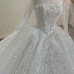 Chiếc váy cưới màu trắng lộng lẫy với thiết kế đính đá sang trọng và tinh xảo.