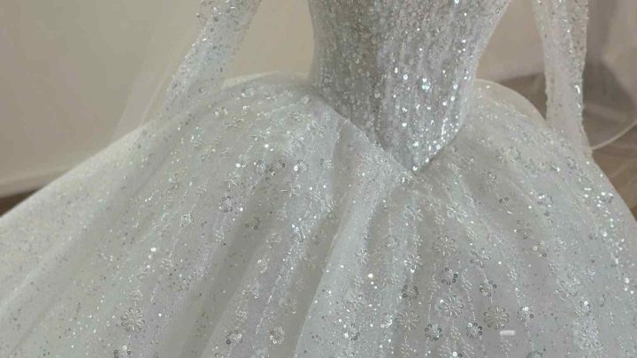 Chiếc váy cưới màu trắng lộng lẫy với thiết kế đính đá sang trọng và tinh xảo.