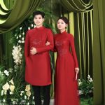Cặp đôi diện áo dài đỏ truyền thống tạo dáng sang trọng trong studio.