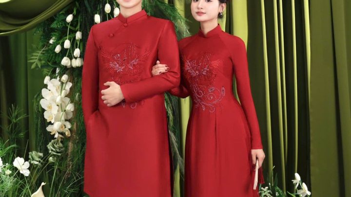 Cặp đôi diện áo dài đỏ truyền thống tạo dáng sang trọng trong studio.