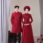 Cặp đôi mặc áo dài đỏ truyền thống tạo dáng trong studio.