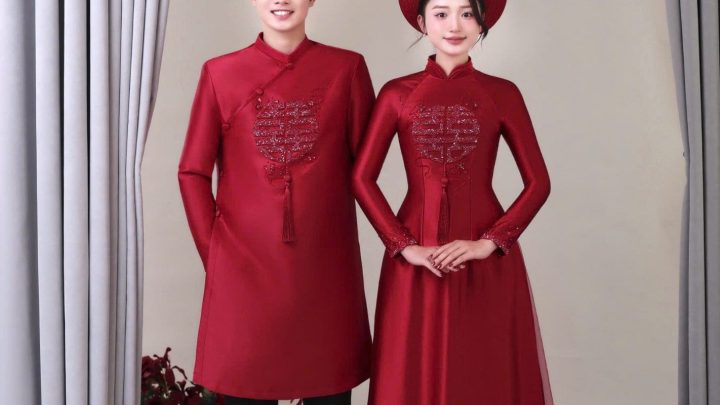 Cặp đôi mặc áo dài đỏ truyền thống tạo dáng trong studio.