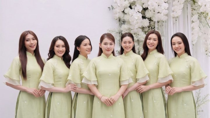 Nhóm phụ nữ mặc áo dài màu xanh pastel thanh lịch chụp tại studio với decor hoa trắng.