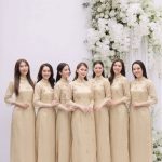 Nhóm các cô gái mặc áo dài màu champagne thanh lịch trong studio.