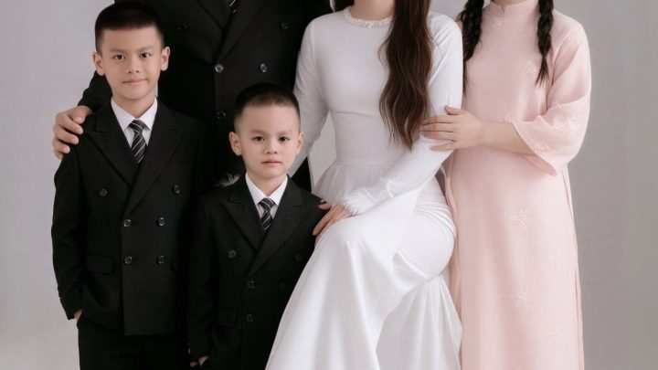 Ảnh chụp gia đình kỷ niệm 11 năm ngày cưới với trang phục áo dài và vest sang trọng tại studio.